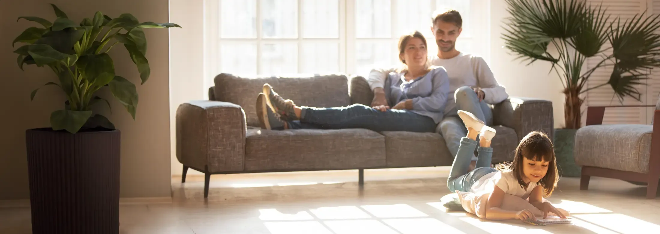 parents relaxing on couch watching daughter color in pest free home